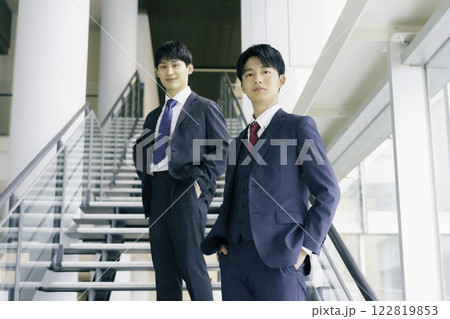 オフィスビルの階段に立つ若いビジネスマン2人のポートレート オフィスビルの階段に立つ若いビジネスマン2人のポートレート 122819853