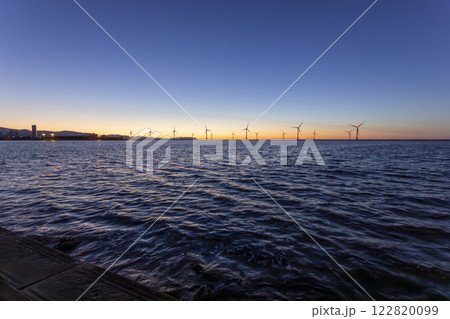 日没の花畔埠頭と洋上風力発電塔 122820099