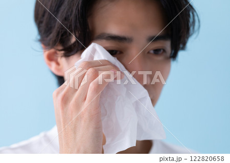 目元にティッシュをあてている男性のイメージ　(写真素材) 122820658