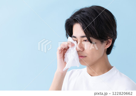 目元にティッシュをあてている男性のイメージ　(写真素材) 122820662