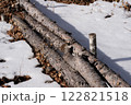 積雪に覆われた森の中に佇む丸太がある冬の風景 122821518
