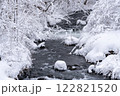 白銀の雪に包まれた東北地方の静寂な冬の渓流の風景 122821520