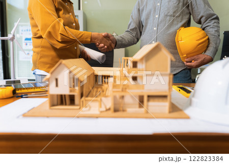 architects and engineers shake hands while working for teamwork. 122823384