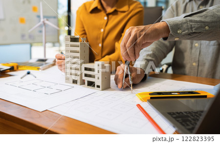 Architect team working with blueprints for sketching a construction project. Architect team working with blueprints for sketching a construction project. 122823395