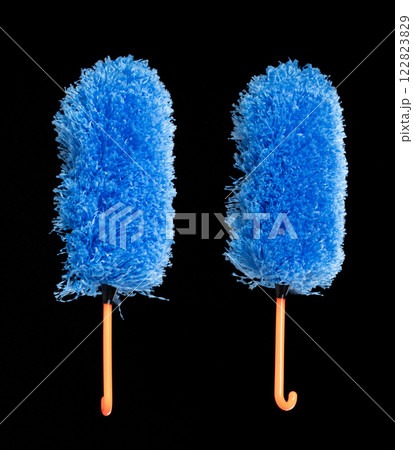 Blue microfiber Duster stick made from synthetic to clean house dust and web. Room Ceiling and window covered with dust bunnies, cobweb cleaned by microfiber duster stick. Black background isolated 122823829