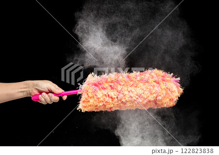 Orange microfiber Duster stick made from synthetic to clean house dust and web. Room Ceiling and window covered with dust bunnies, cobweb cleaned by microfiber duster stick. Black background isolated 122823838