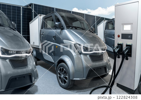Electric vehicles charging station on a background of a small city delivery trucks Electric vehicles charging station on a background of a small city delivery trucks 122824308