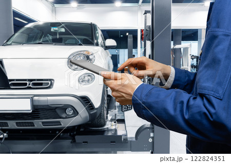 Serviceman with digital tablet on the background of the car in the car service 122824351