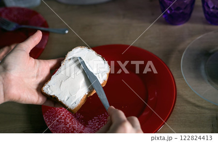 hand spreads cottage cheese on bread hand spreads cottage cheese on bread 122824413