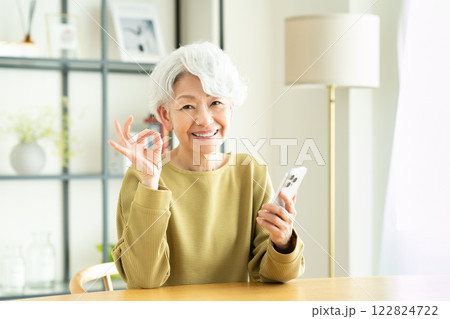自宅でスマホを使う若い女性 自宅でスマホを使う若い女性 122824722