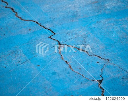 Cracked blue surface urban setting close-up industrial environment ground level texture analysis 122824900