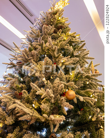Close-up view of a joyful christmas tree in a cozy indoor holiday environment Close-up view of a joyful christmas tree in a cozy indoor holiday environment 122824924