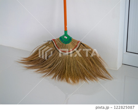 Housekeeping action cleaning with a broom indoor space home environment close-up view daily chores Housekeeping action cleaning with a broom indoor space home environment close-up view daily chores 122825087