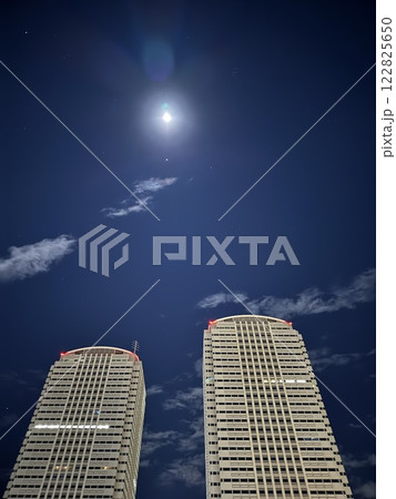 月が輝く夜空と高層ビル 122825650