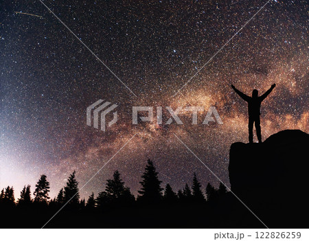 Silhouette young man background of the Milky Way galaxy on a bright star dark sky tone Silhouette young man background of the Milky Way galaxy on a bright star dark sky tone 122826259