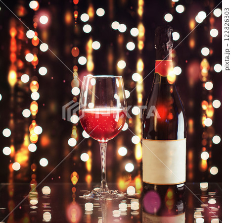 Red wine glass with bottle on background lights. Happy new year Red wine glass with bottle on background lights. Happy new year 122826303
