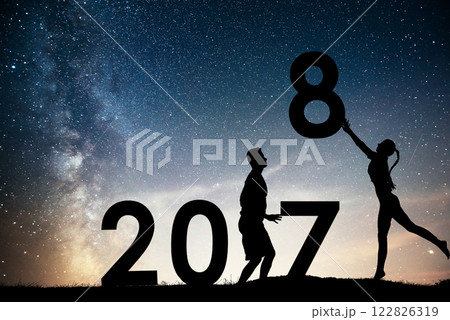 Silhouette young girl and guy. Happy 2018 new year. Background of the Milky Way galaxy on a bright star dark sky tone. Concept change year 2017 to 2018 Silhouette young girl and guy. Happy 2018 new year. Background of the Milky Way galaxy on a bright star dark sky tone. Concept change year 2017 to 2018 122826319