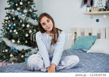 Beautiful girl lies on a bed in pajamas on Christmas morning 122826536
