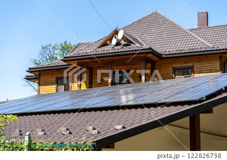 Solar panels on the roof of a residential building wooden house in a village. 122826738