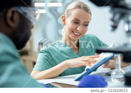 Colleagues man and woman sitting at workplace in laboratory Colleagues man and woman sitting at workplace in laboratory 122828023