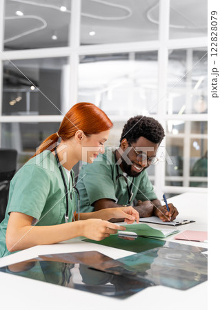 Redhead woman and male doctor having conversation about patient’s bone care 122828079