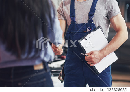 husband car mechanic and woman customer make an agreement on the repair of the car husband car mechanic and woman customer make an agreement on the repair of the car 122828685