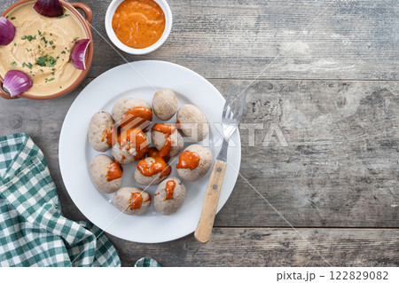 Papas arrugadas with mojo and gofio escaldado on wooden table. Traditional Canary Islands food. 122829082