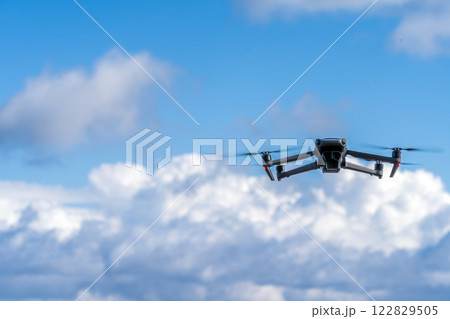 青空を飛行するドローン 122829505