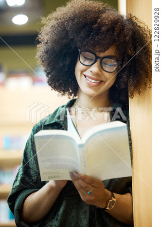 Library, books and education with a woman student reading in a bookstore on university or college campus. Study, scholarship and learning for an exam and test for knowledge, growth and development 122829928