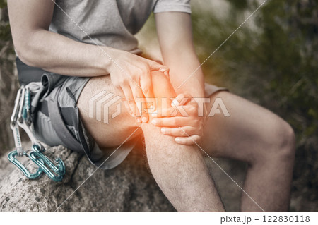 Knee, injury and pain with a man sitting on a rock to take a break while out hiking, rock or mountain climbing in nature. CGI of discomfort from cramp during exercise or sports training in a forest Knee, injury and pain with a man sitting on a rock to take a break while out hiking, rock or mountain climbing in nature. CGI of discomfort from cramp during exercise or sports training in a forest 122830118
