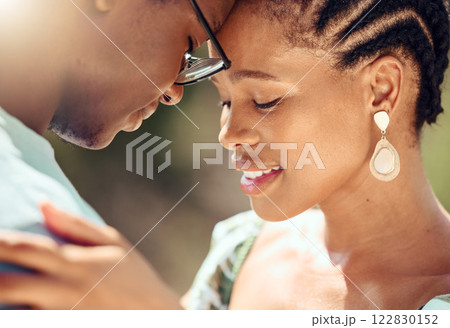Happy couple hugging in nature while on a romantic date while bonding in the park. Closeup of care, love and young man and woman embracing each other in an outdoor garden during spring. 122830152