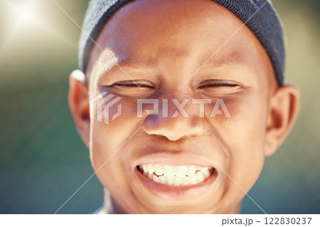 Children, face and teeth with a black boy outside with a big smile and eyes closed. Kids, head and joy with a carefree little male child standing outdoors alone with flare and a positive expression 122830237