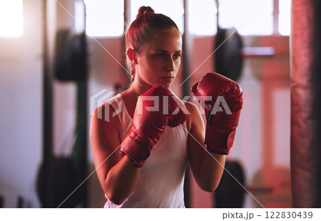 Boxing, training and woman or boxer in gym exercising for fitness, motivation and workout. Sport, wellness and health with girl fighter or athlete in sports club ready to train for exercise or fight. Boxing, training and woman or boxer in gym exercising for fitness, motivation and workout. Sport, wellness and health with girl fighter or athlete in sports club ready to train for exercise or fight. 122830439