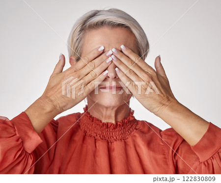 Senior, hands and covering eyes or face of mature woman suffering with a headache or eye strain while posing against a grey studio background. Elderly woman having problems with her vision or sight. Senior, hands and covering eyes or face of mature woman suffering with a headache or eye strain while posing against a grey studio background. Elderly woman having problems with her vision or sight. 122830809