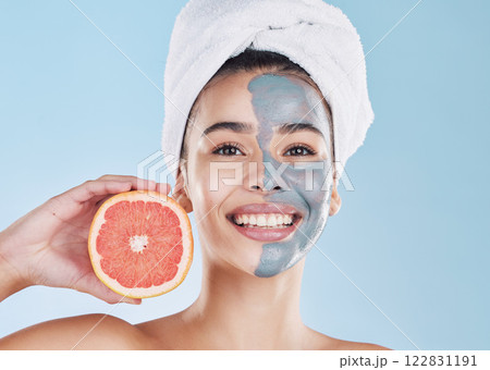 Woman, skincare and grapefruit face mask, organic beauty and wellness for healthy face, fresh facial and natural clean glowing skin on blue background. Portrait, smile and model grooming bodycare 122831191