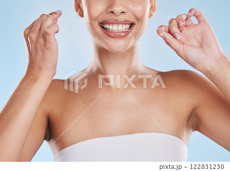 Dental floss, teeth and healthy smile with a beautiful young woman flossing for oral hygiene and gum health. Closeup of a happy female cleaning her mouth during her selfcare wellness routine 122831230