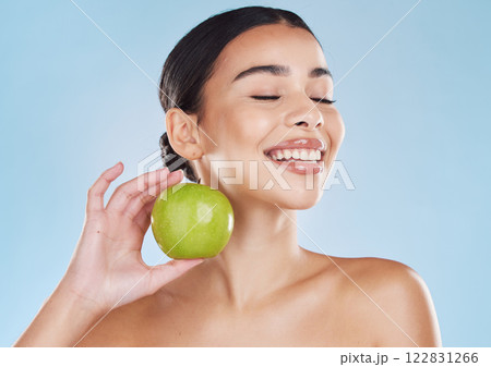 Health, skincare and beauty woman with an apple for wellness, healthy and organic lifestyle in studio. Girl with clear, fresh and natural skin holding a fruit with vitamins and nutrition for a diet 122831266