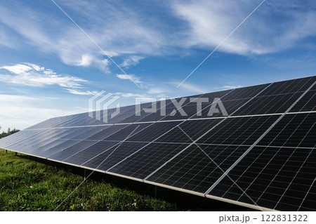 Solar panels absorbing sunlight under a cloudy blue sky Solar panels absorbing sunlight under a cloudy blue sky 122831322