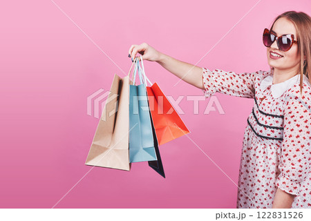 Portrait of young happy smiling woman with shopping bags on the pink Background Portrait of young happy smiling woman with shopping bags on the pink Background 122831526
