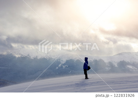 Snowshoe walker running in powder snow with beautiful sunrise light. Outdoor winter activity and healthy lifestyle 122831926