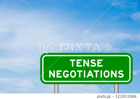 Green color transportation sign with word tense negotiations on blue sky with white cloud background Green color transportation sign with word tense negotiations on blue sky with white cloud background 122831986