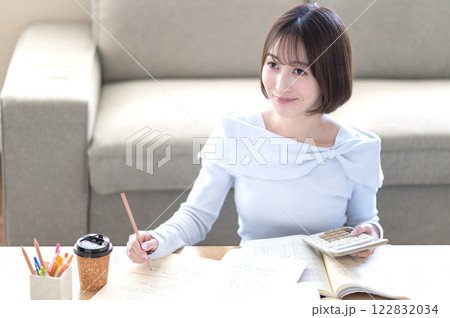 リビングで一人で勉強する若い女性 リビングで一人で勉強する若い女性 122832034