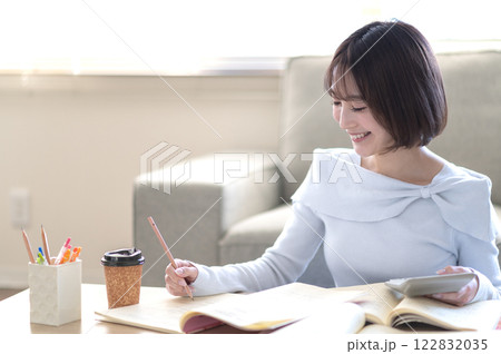 リビングで一人で勉強する若い女性 122832035