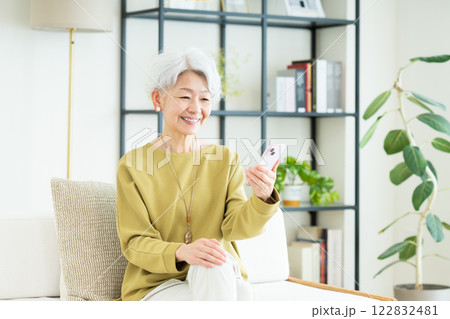 リビングでスマホを使うシニアの女性 リビングでスマホを使うシニアの女性 122832481