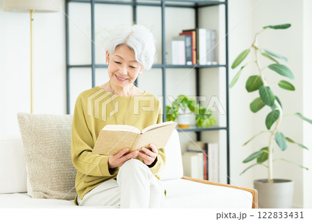リビングで読書するシニアの女性 122833431