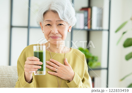 リビングで青汁を飲むシニアの女性　 122833459