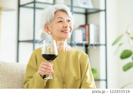 リビングでワインを飲むシニアの女性 リビングでワインを飲むシニアの女性 122833519