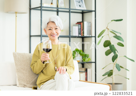 リビングでワインを飲むシニアの女性 リビングでワインを飲むシニアの女性 122833521