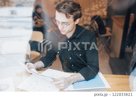 Young entrepreneur working in a cafe Young entrepreneur working in a cafe 122833621