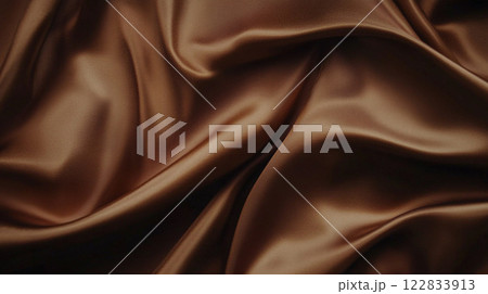 Piece of brown fabric with a pattern on it. The fabric is very soft and smooth. It is used for a dress or a piece of clothing 122833913